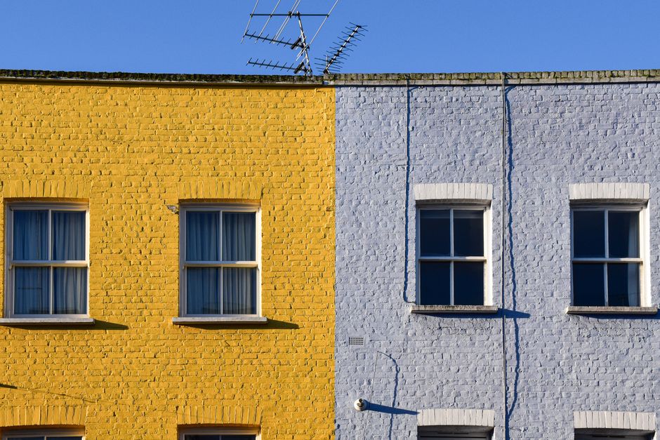 Row of painted houses with yellow and blue walls.